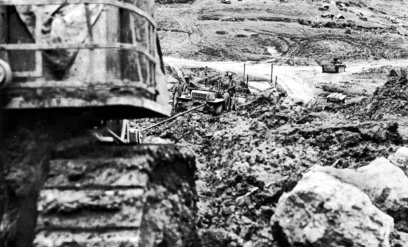 Bulldozer towing a scout vehicle in a sea of mud