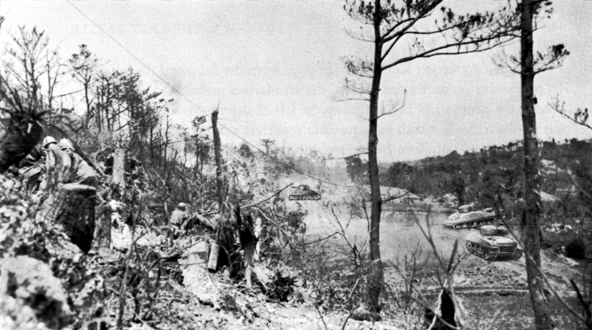 YUZA PEAK, under attack by the 382d Infantry, 96th Division. Tanks are working on the caves and tunnel system at base ridge of ridge.