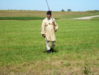 Photo: An interpreter dressed in Jeffersonian era “fatigue uniform” stands guard at the U.S. Army Corps of Engineers period encampment located at the exact site (Independence Creek) that Lewis and Clark commemorated the Fourth of July in 1804.  This camp was actually located several miles outside modern day Atchison.  The State of Kansas installed a marker at the actual site.