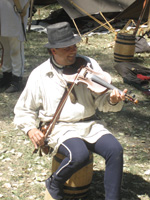 Photo:  A U.S. Army Corps of Engineers interpreter portraying Private George Gibson, a fiddle playing member of Lewis and Clark’s permanent party.  Gibson, born in Pennsylvania, was living on the Kentucky frontier by the time Clark had recruited him in Liousville. Gibson proved to be one of the best hunters in the expedition.
