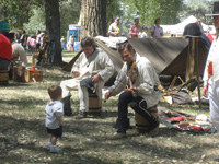 Photo:  Drawn by the sounds of Gibson’s fiddle playing, another young visitor arrives at the U.S. Army Corps of Engineers Lewis and Clark encampment on the Yellowstone River.