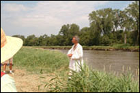 Photo: Scott Mandrell, the principal spokesman of the St. Charles Corps of Discovery, and portraying Captain Meriwether Lewis, interprets the history of the Lewis and Clark expedition at Boyer Chute National Wildlife Refuge, a satellite location of the 'First Council' Lewis and Clark signature event, July 31-August 3, 2004.  With their campsite established and pirogues beached nearby, the members of the St. Charles Corps of Discovery accurately portrayed the original Corps with 1804 military dress and drill.