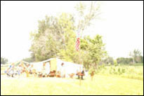 Photo: Encampment of the St. Charles Corps of Discovery living history interpreters at Boyer Chute National Wildlife Refuge, a satellite location of the 'First Council' Lewis and Clark signature event, July 31-August 3, 2004.  With the keelboat and pirogues moored nearby, the members of the St. Charles Corps of Discovery accurately portrayed the original Corps with 1804 military dress and drill.