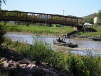 Photo: The interpreters sailing up the Missouri River were escorted by boats from the 200th Engineer Company (Bridge) of the South Dakota Army National Guard.  One of the Army watercraft, which are used to push floating bridge sections into position, is shown here transporting SSG Scott Mandrell (Montana National Guard) to shore.  SSG Mandrell has done an outstanding job portraying Captain Meriwether Lewis during the recreated expedition.
