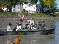 Photo: Two hundred years of military tradition – Current day soldiers of the South Dakota Army National Guard transport the interpreters of the Lewis and Clark expedition out to the Keelboat anchored in the middle of the Missouri River.