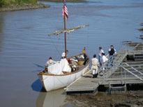Photo: Close up of Lewis and Clark reenactors from St. Charles, Missouri are depicted here mooring the white pirogue at Fort Pierre, South Dakota on 24 September 2004.  The men are clad in fatigue uniforms.  The individual wearing the red stocking cap is portraying one of the contract boatmen.