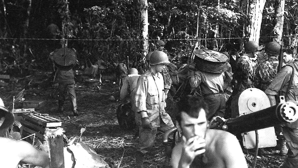 Photo:  Members of the 43d Signal Company carry wire reels into the jungle of New Georgia, July 1943