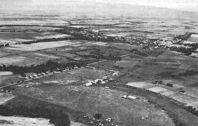 Photo:  San Fernando, looking northwest.  Route 3 from Calumpit runs diagonally through the photograph; Route 7 leading to Bataan is in upper left.  Zambales Mountains are visible in the background.