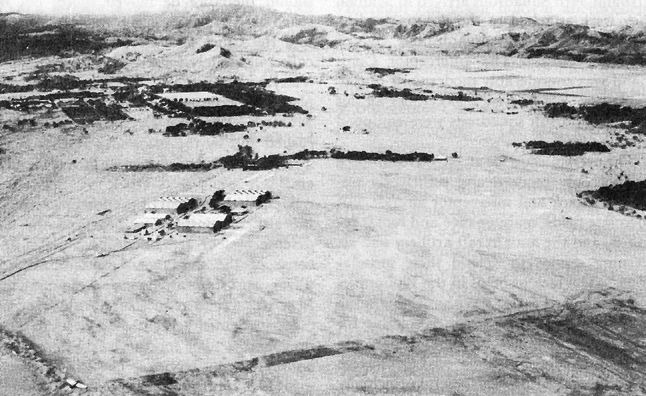 Photo:  Clark Field looking westward.  In the upper left center, abutting the foothills of the Zambales Mountains, lies Fort Stotsenburg.  The rectangular, tree-lined area is the parade ground.