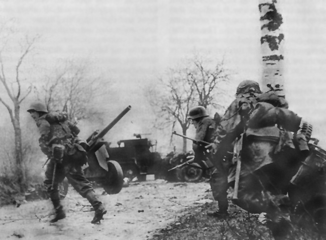 Photo:  German troops advancing past abandoned American equipment