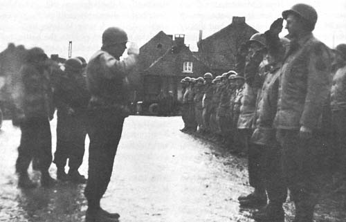 Photo:  Colonel Bliss salutes Sergeant Salvesen and Technicians Pavlik and Swanson after they received Bronze Stars for capturing three German spies of Operations GREIF