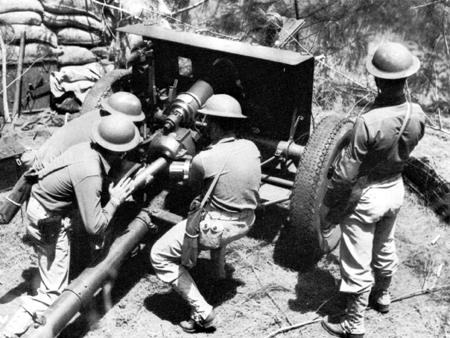 Photo: TROOPS ON MANEUVERS IN HAWAII, 1941, PREPARE TO RESIST INVASION. Loading a 75-mm. gun.