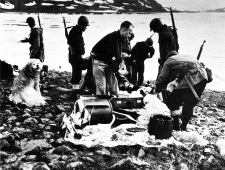 Photo: TROOPS EXAMINE GERMAN PARACHUTE KIT found at site of abandoned German radio base in Greenland.