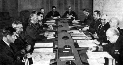 Photo - The Combined Chiefs of Staff during a meeting in October 1942 Left to right: Comdr. R. D. Coleridge, Rear Adm. W. R. Patterson, Field Marshal Dill, Brigadier Vivian Dykes, Lt. Gen. G.  MacReady, Air Marshal D. C. S. Evill, Lt. Col. T. W. Hammond, Jr., Lt. Gen. J. T. McNarney, General Marshall, Brig. Gen. J. R. Deane, Admiral Leahy, Admiral King and Vice Adm. F. J. Horne.