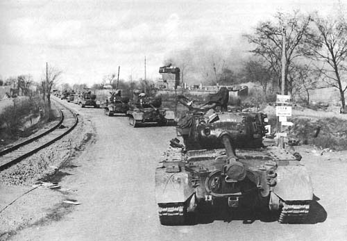 Photo:  Convoy of Pershing Tanks moves through a German town