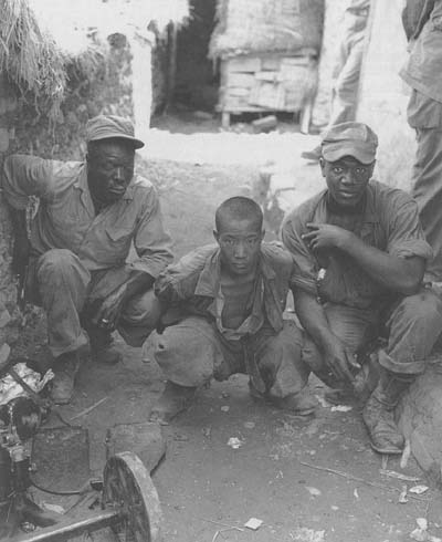 Two American soldiers with a North Korean prisoner of war, 5 August 1950