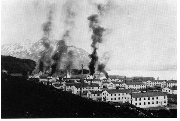 Buildings burning after the first enemy attack on Dutch, Harbor, 3 June 1942.