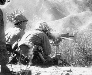 Japanese troops firing a heavy machine gun.