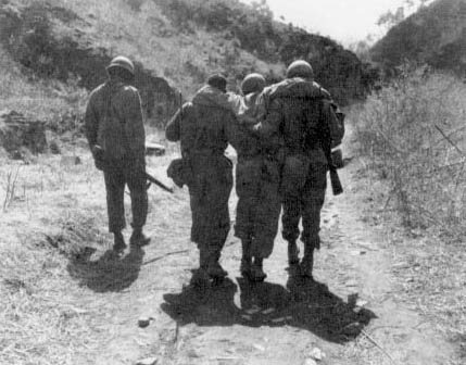 Photo, Wounded 25th Division infantryment escorted to an aid station