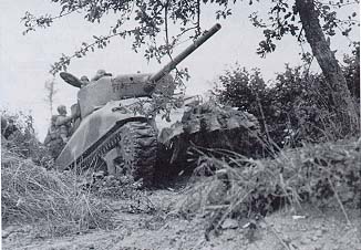 Photo, Tank, modified with iron teeth, cuts through the bocage.