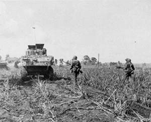 27th Division troops advance behind tanks on Saipan.
