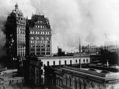 Photo:  SC95215 - Area in the vicinity of Kearny, Third, Market and Geary Streets. The large building is the Claus Spreckels or Call Building. Flames can be seen coming from the windows of the Call Building. The Mutual Bank building and other structures in the foreground were not consumed by fire at this time but in later pictures the whole area was in ruins. 