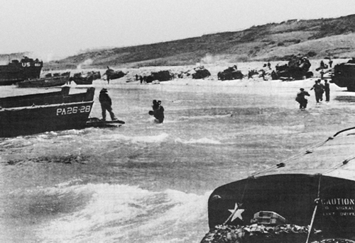 Photo:  Tanks and vehicles stalled at the shingle line on OMAHA Beach