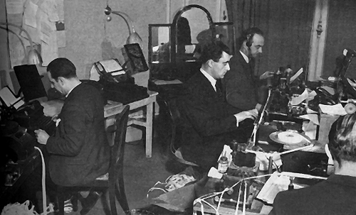 Photo:  Newsmen at work in an improvised press wireless room