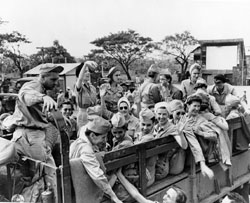 Manila during February 8-12, 1945. 
	   U.S. Army Nurses from Bataan and Corregidor, freed after three years imprisonment in Santo Tomas Interment Compound, climb into 
	   trucks as they leave Manila, Luzon, P.I.