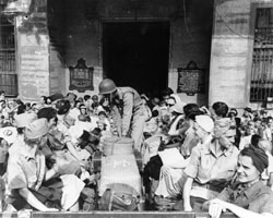 US Army nurses from Bataan and 
	   Corregidor, freed after 3 years imprisonment in Santo Tomas Internment Compound climb into trucks as they Leave Manila, Luzon, 
	   P.I.