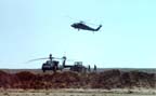 UH-60A Blackhawk flying over CH-47Ds in dispersal berms